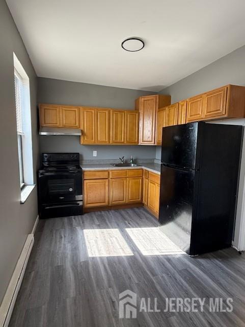 a kitchen with granite countertop wooden floors and a refrigerator