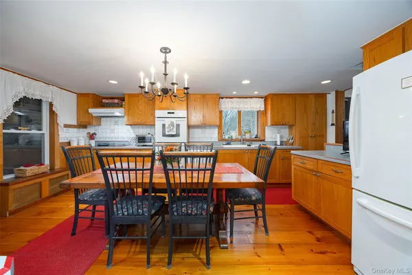 a dining area with stainless steel appliances a dining table chairs and a refrigerator