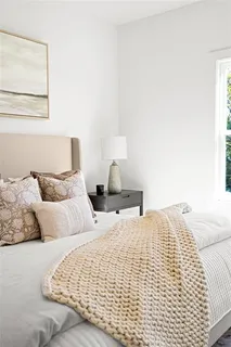 a bedroom with a bed and a painting on the wall