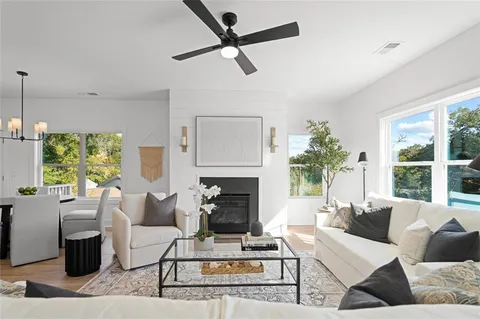 a living room with furniture a fireplace and a large window