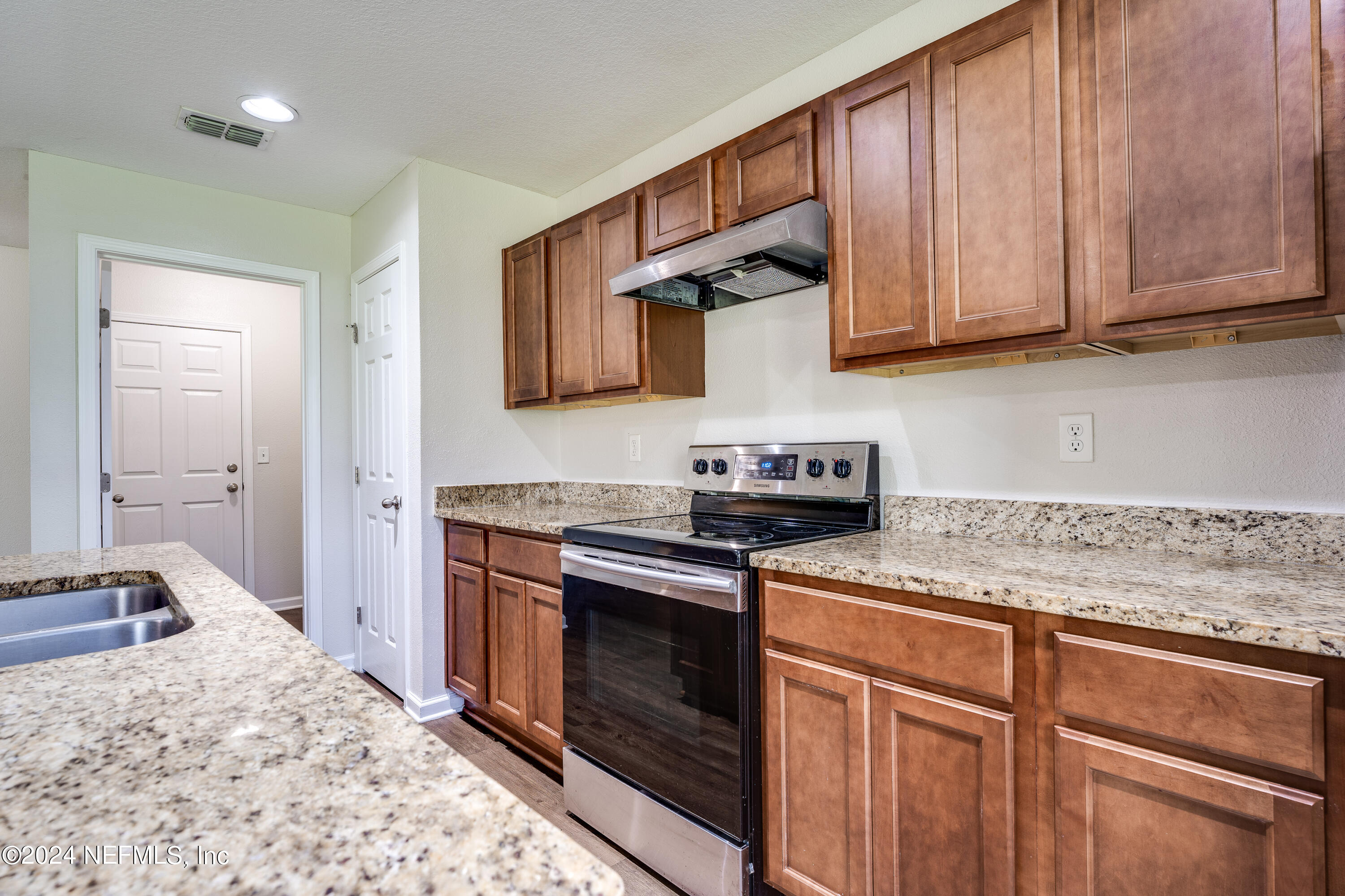 956 Revels Road Jacksonville, FL 32205 - Photo 10 of 26 a kitchen with stainless steel appliances granite countertop a stove sink and cabinets