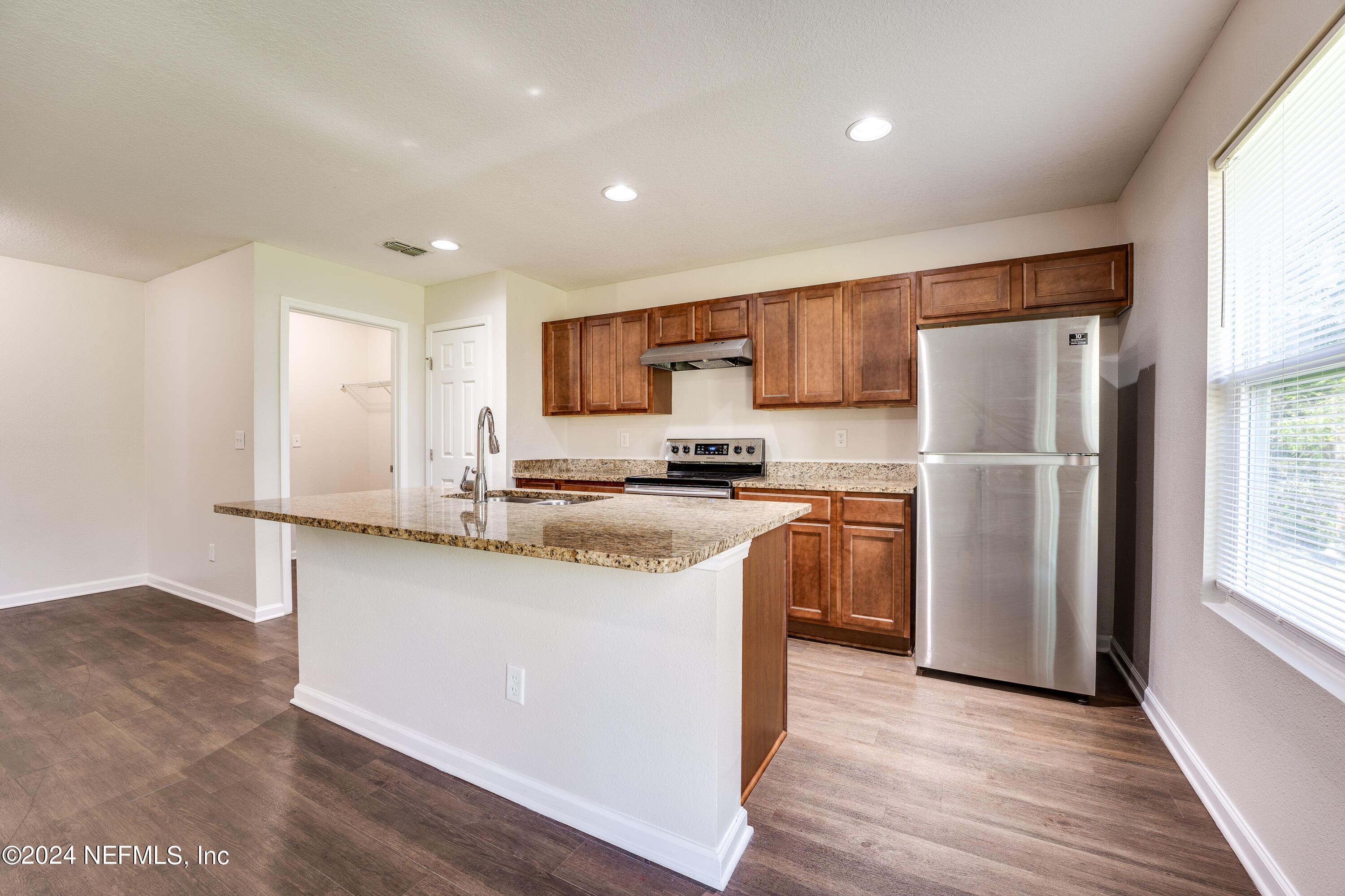 956 Revels Road Jacksonville, FL 32205 - Photo 9 of 26 a kitchen with stainless steel appliances granite countertop a refrigerator a sink a stove a microwave and island with wooden floor