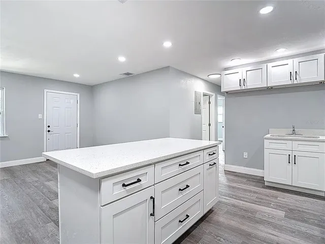 a kitchen with a stove and a wooden floor