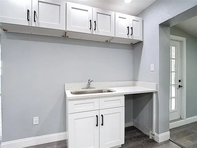 a kitchen with cabinets appliances and a wooden floor