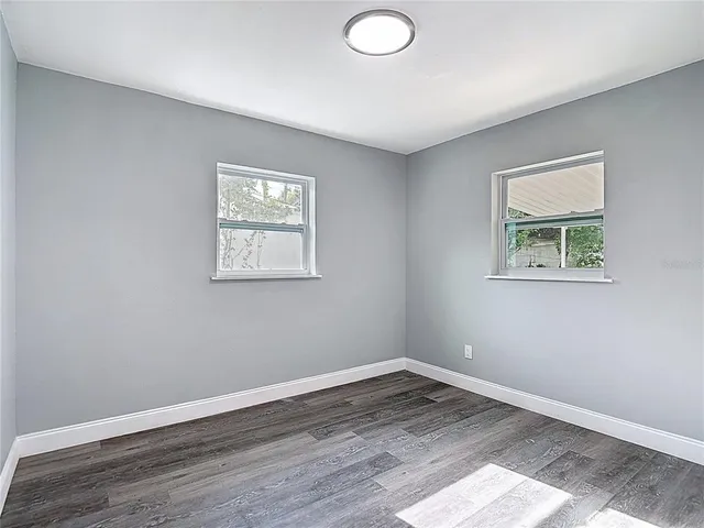 a view of an empty room with wooden floor