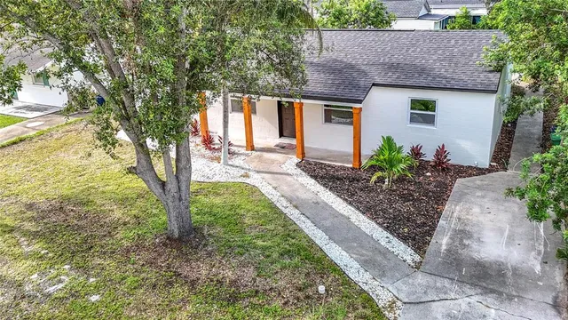 an aerial view of residential houses with outdoor space and trees