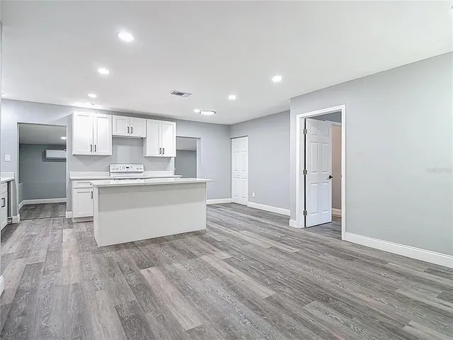 a kitchen with white cabinets appliances a sink and a window