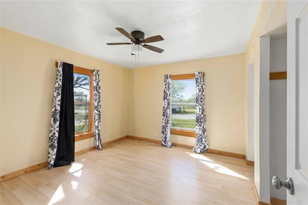 a view of empty room with window and ceiling fan
