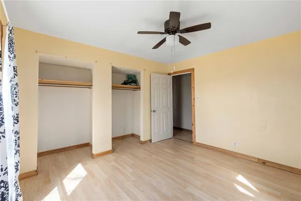 a view of a livingroom with a ceiling fan & entryway