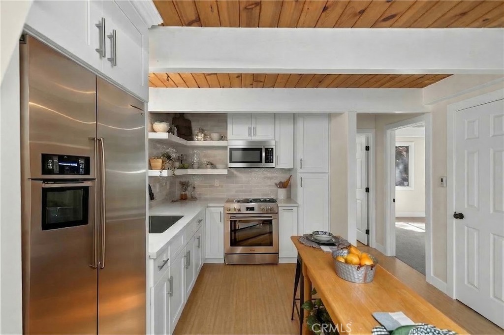 26980 Everest Road Lake Arrowhead, CA 92391 - Photo 12 of 49 a kitchen with stainless steel appliances a stove a sink and a refrigerator