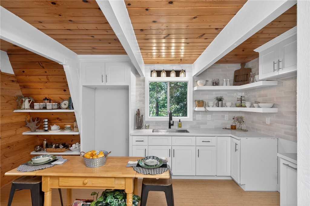 26980 Everest Road Lake Arrowhead, CA 92391 - Photo 17 of 49 a kitchen with a sink a stove and cabinets