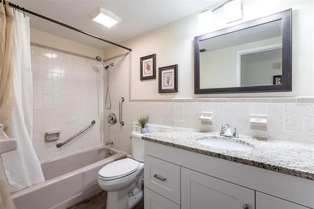 a bathroom with a granite countertop toilet sink and mirror