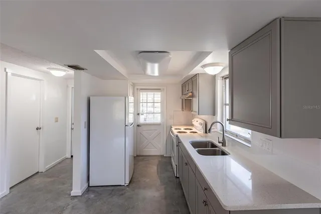 a kitchen with stainless steel appliances granite countertop a sink and a refrigerator