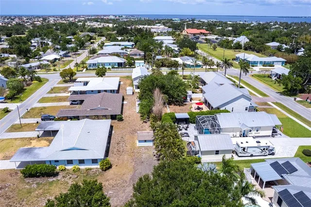 an aerial view of a house with swimming pool and large trees