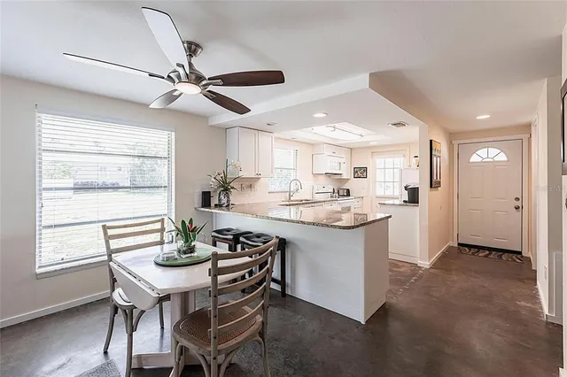 a kitchen with kitchen island a sink dining table and chairs