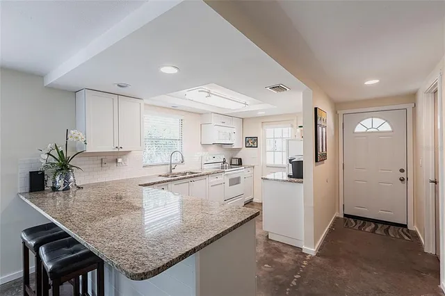 a kitchen with granite countertop kitchen island a counter space and stainless steel appliances