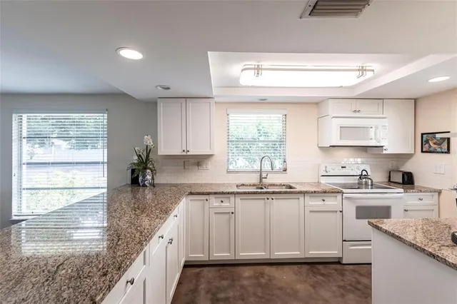 a kitchen with a sink dishwasher window and cabinets