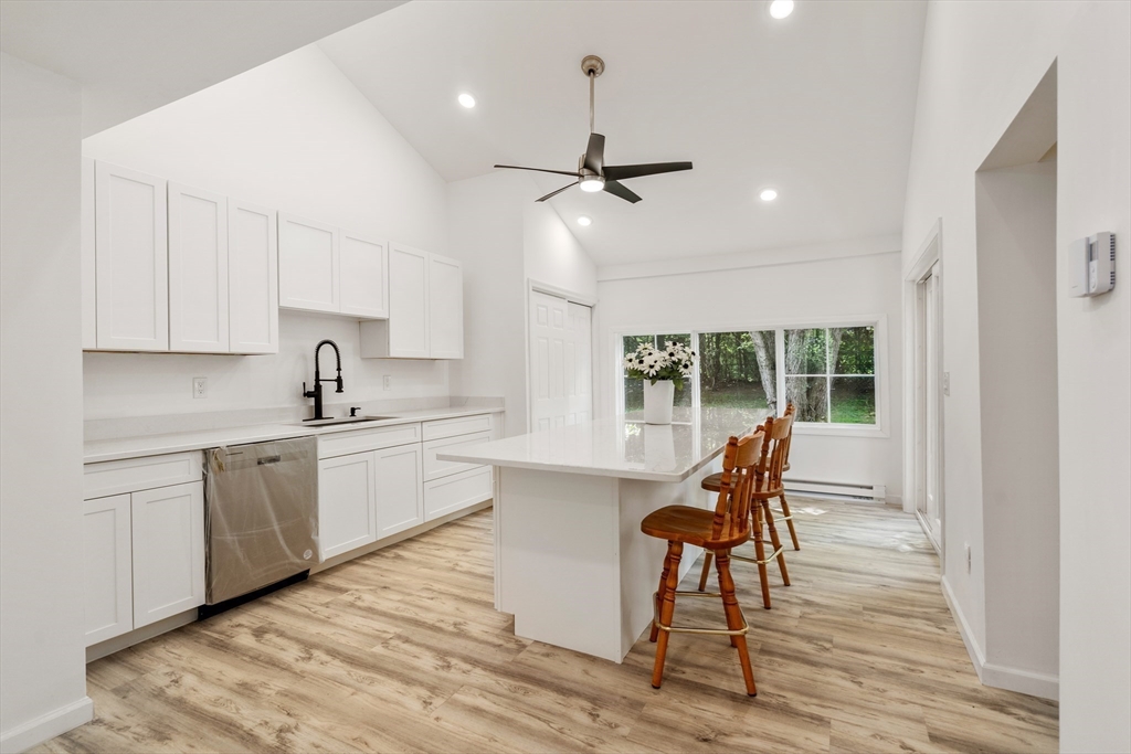 87 Vincent Street Springfield, MA 01129 - Photo 7 of 32 a kitchen with stainless steel appliances kitchen island granite countertop a stove a sink and white cabinets with wooden floor