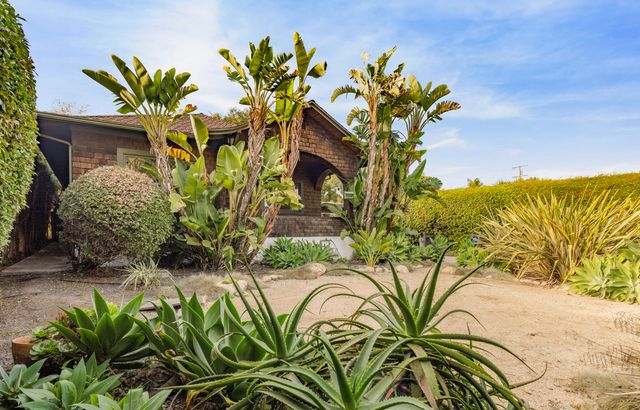 a front view of a house with a yard and a bench
