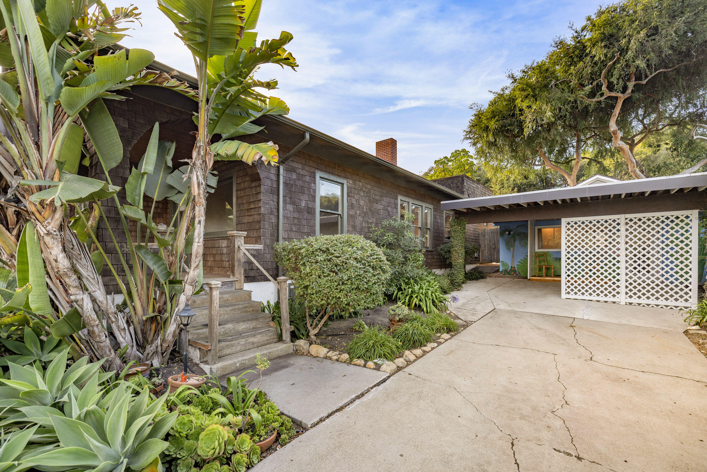 1126 Las Olas Avenue Santa Barbara, CA 93109 - Photo 5 of 24 a front view of a house with a yard and a bench