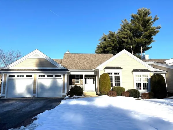 a front view of a house with yard and parking