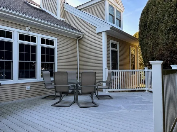 a view of a deck with table and chairs with wooden floor and fence