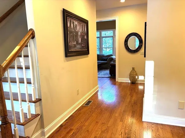 a view of a hallway with wooden floor and furniture