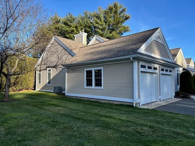 a front view of house with yard and trees in the background