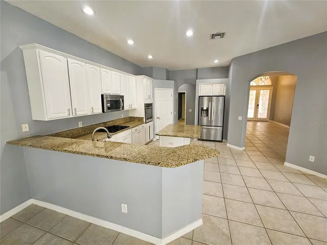 a kitchen with granite countertop a sink a stove and cabinets