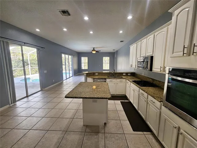 a large kitchen with stainless steel appliances lots of counter space and a window
