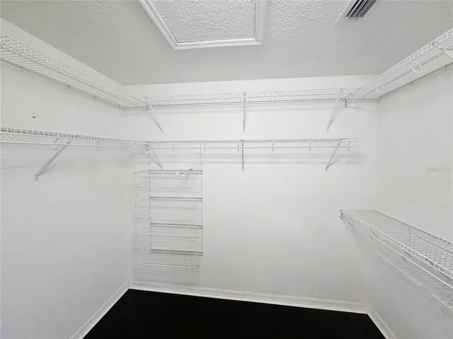 a view of walk in closet with empty racks