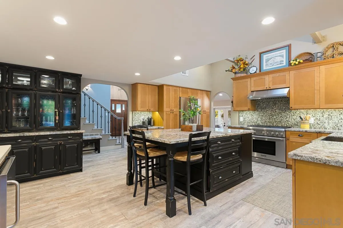 3526 Avenida Sierra Escondido, CA 92029 - Photo 5 of 36 a kitchen with stainless steel appliances granite countertop a stove top oven a sink dishwasher a dining table and chairs with wooden floor