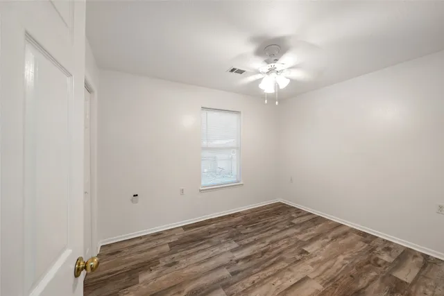 wooden floor in an empty room with a window