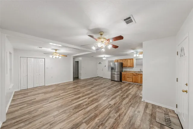 a view of empty room with wooden floor