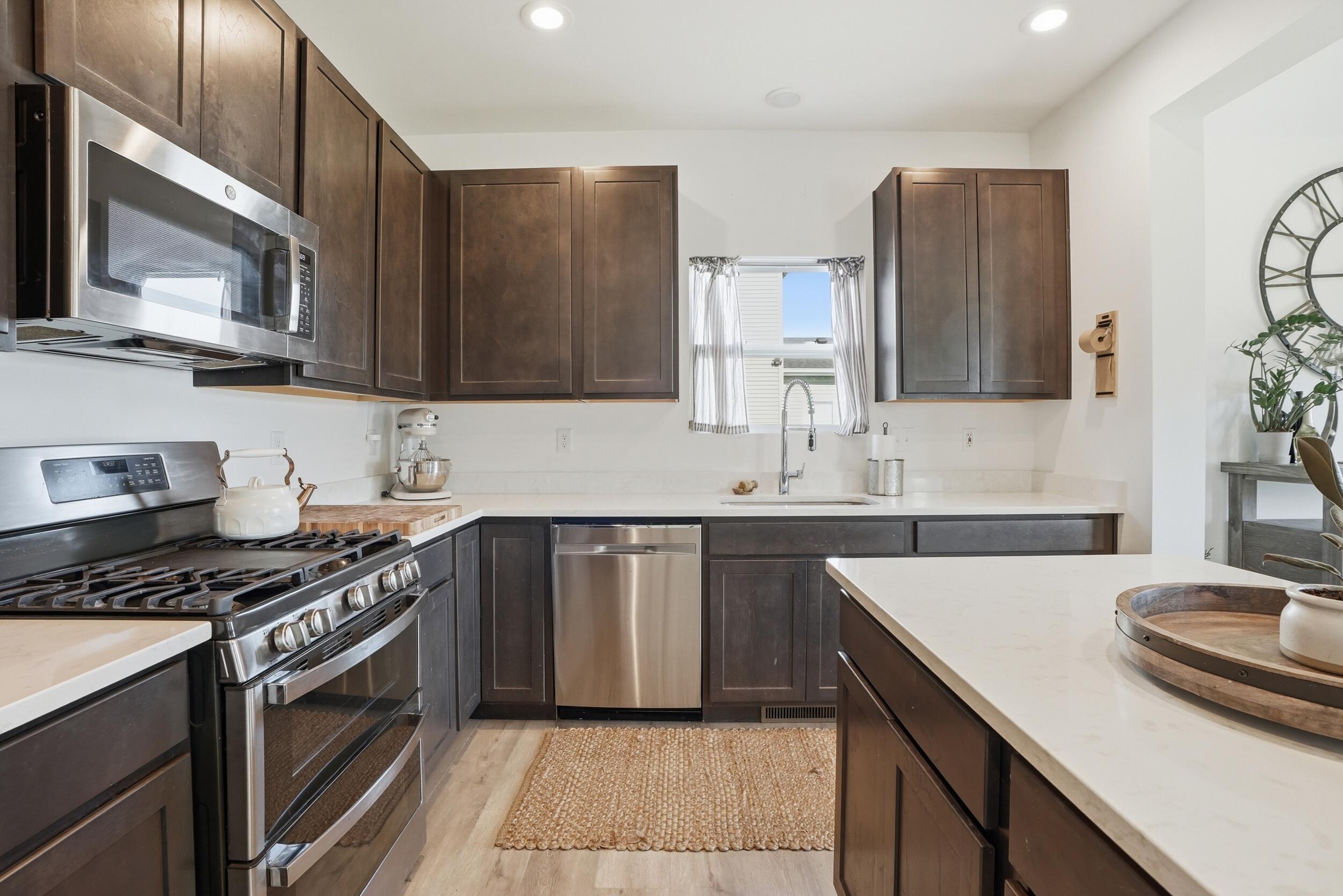 8658 Valley Forge Way Lowell, IN 46356 - Photo 10 of 23 a kitchen with stainless steel appliances granite countertop a sink stove and cabinets