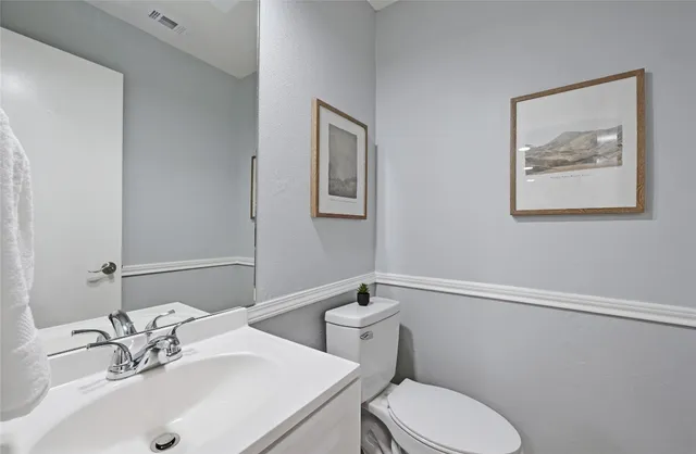 a bathroom with a sink mirror and toilet