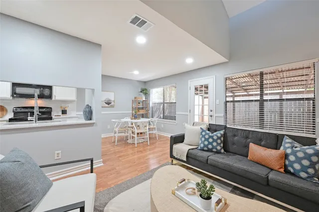 a living room with furniture and wooden floor