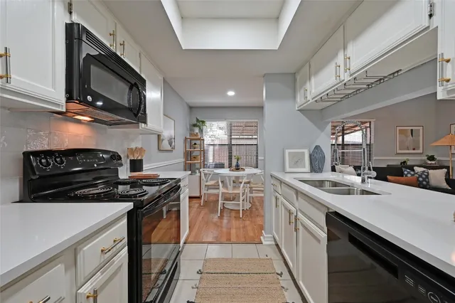 a kitchen with stainless steel appliances a stove a sink and a microwave