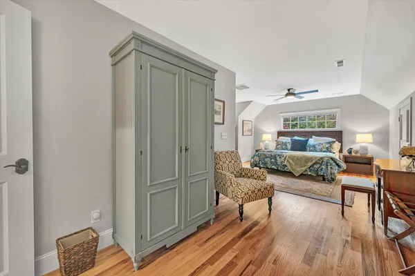 a bedroom with a bed and a lamp on the dresser