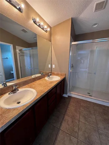 a bathroom with a double vanity sink and a mirror