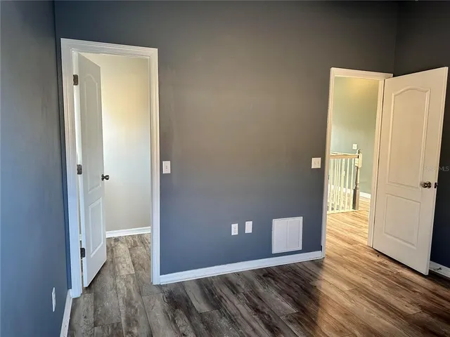 a view of a hallway with wooden floor and a cabinet
