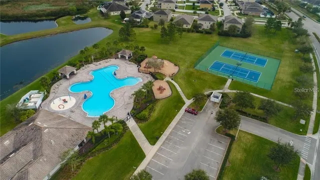 an aerial view of a house with outdoor space pool patio seating area and yard