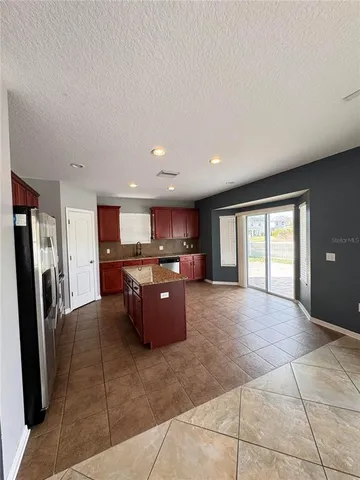 a large open kitchen with a refrigerator a stove top oven and a sink