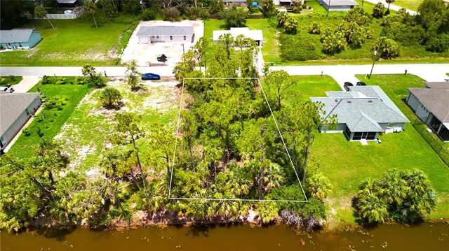 an aerial view of residential houses with outdoor space and trees