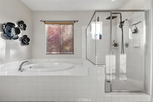 a bedroom with a white bed dresser and a window