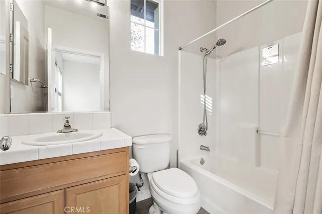 a view of a bedroom with wooden floor & windows