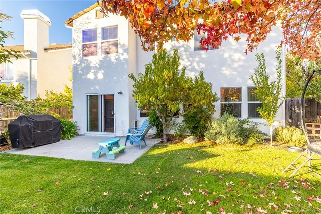 a view of a house with backyard and a tree