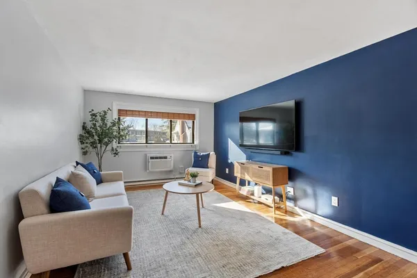a living room with furniture a flat screen tv and a large window