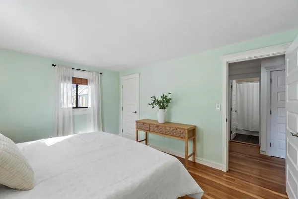 a bedroom with a bed and wooden floor