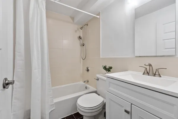 a bathroom with a toilet a sink and curtain